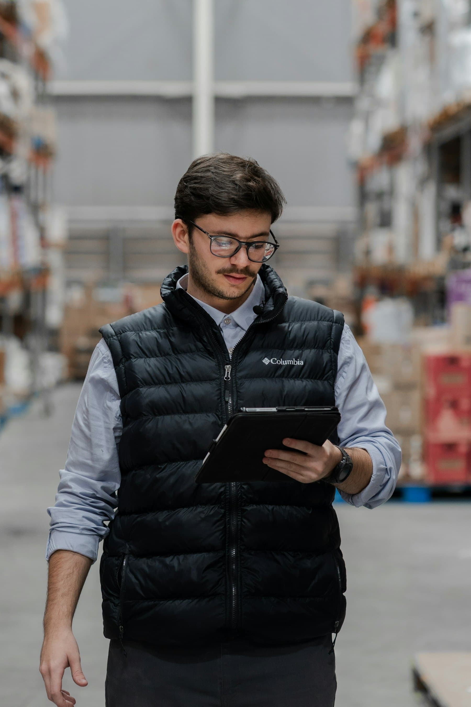 Logistics operator reviewing shipment movement on a warehouse tablet